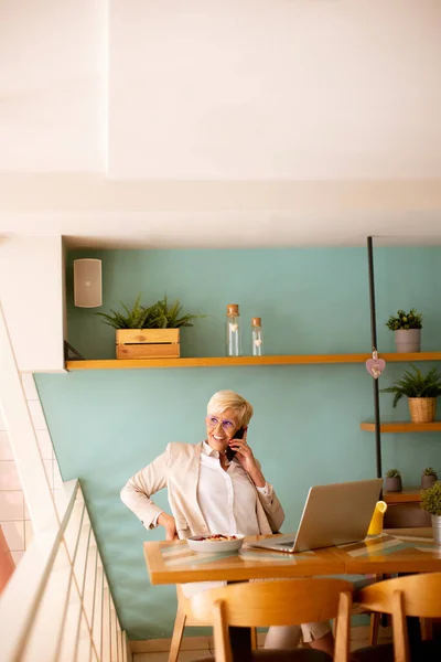Senior Woman Using Mobile Phone While Working Laptop Having Healthy — Stock Photo, Image