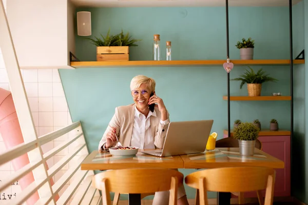 Üst Düzey Kadın Laptopta Çalışırken Cep Telefonu Kullanıyor Kafede Sağlıklı — Stok fotoğraf