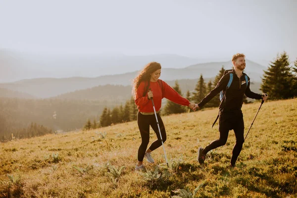 Lächelndes Junges Paar Läuft Mit Rucksack Über Grüne Hügel — Stockfoto