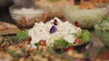 Masadaki çiçeklerle süslenmiş peynirin kapağını kapat.