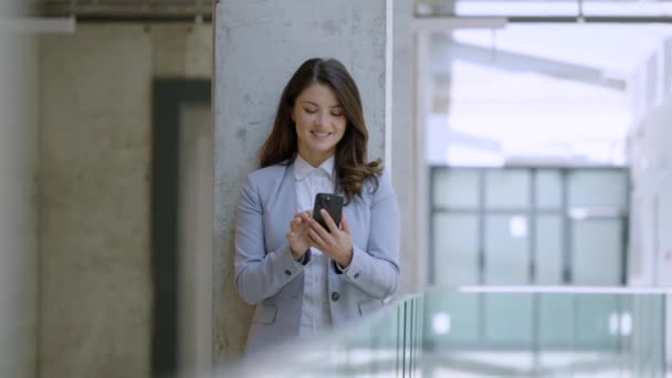 Όμορφη Νεαρή Επιχειρηματίας Που Χρησιμοποιεί Κινητό Τηλέφωνο Στο Διάδρομο Του — Αρχείο Βίντεο