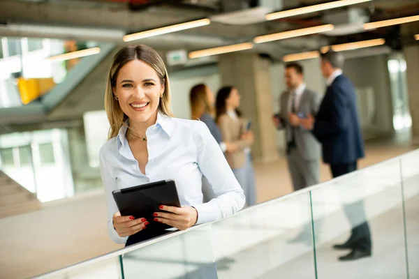 オフィスの廊下にデジタルタブレットを持つ若いビジネス女性 — ストック写真