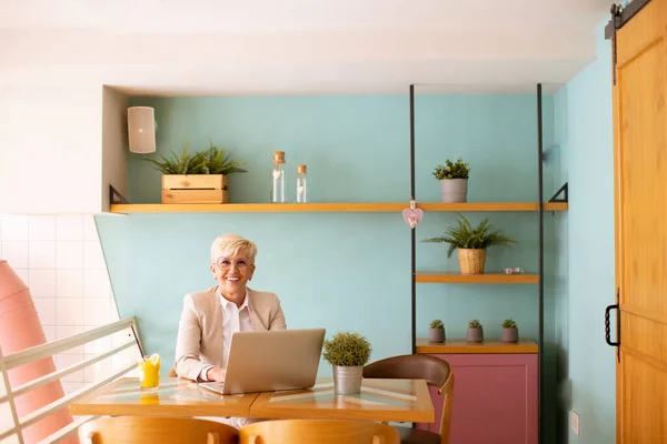 Donna Anziana Che Utilizza Telefono Cellulare Mentre Lavora Sul Computer — Foto Stock