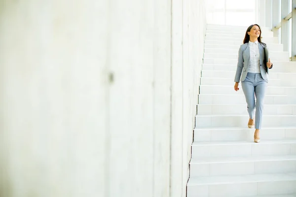 Genç Kadını Merdivenlerden Inip Elinde Dizüstü Bilgisayarla Ofis Koridorunda Yürüyor — Stok fotoğraf
