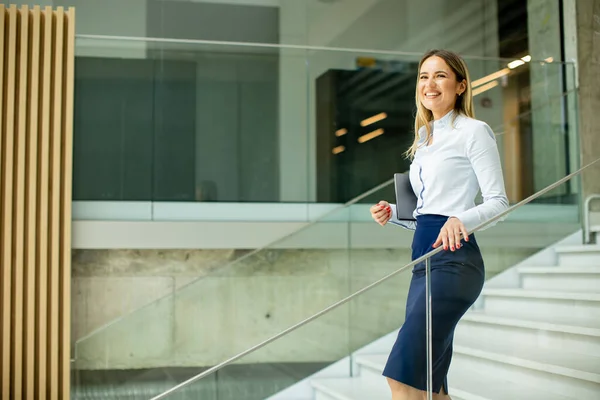 オフィスの廊下の階段を歩くかわいい若いビジネス女性 — ストック写真