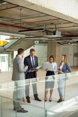 Modern ofis koridorunda çalışan genç girişimci takımı.