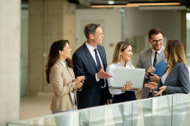 Modern ofis koridorunda çalışan genç girişimci takımı.