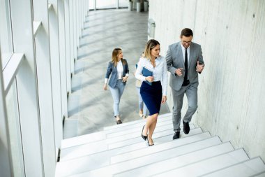 Yeni başlayanlar ofis koridorundaki merdivenlere tırmanırken tartışıyorlar.