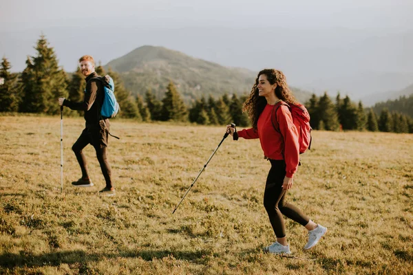 Sorrindo Jovem Casal Andando Com Mochilas Sobre Colinas Verdes — Fotografia de Stock