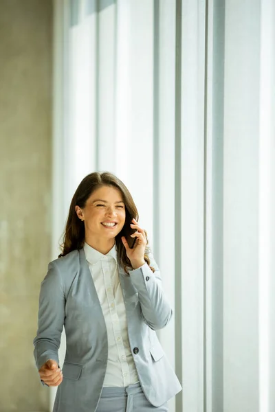 Mujer Bastante Joven Usando Teléfono Móvil Junto Ventana Oficina —  Fotos de Stock