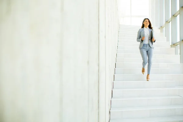 Genç Kadını Merdivenlerden Inip Elinde Dizüstü Bilgisayarla Ofis Koridorunda Yürüyor — Stok fotoğraf