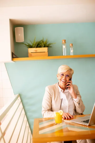 Senior Vrouw Met Behulp Van Mobiele Telefoon Tijdens Het Werken — Stockfoto