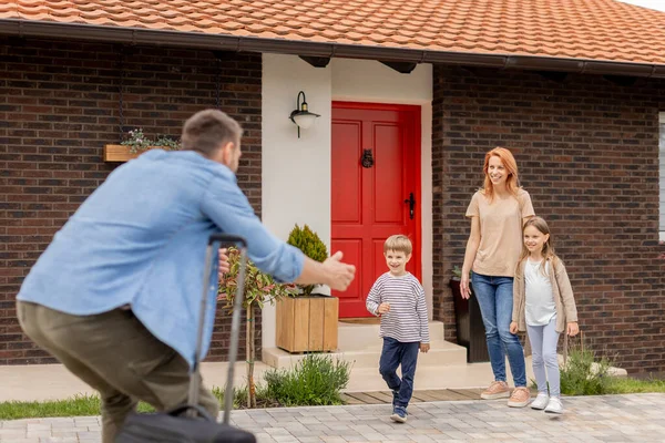 stock image Father came home from the trip and happy son, daughter and wife running to meet him