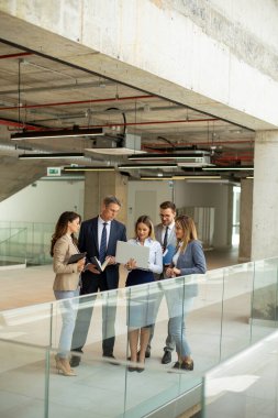 Modern ofis koridorunda çalışan genç girişimci takımı.