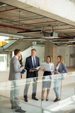 Modern ofis koridorunda çalışan genç girişimci takımı.