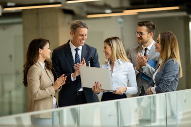 Modern ofis koridorunda çalışan genç girişimci takımı.