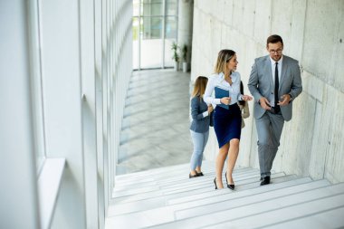 Yeni başlayanlar ofis koridorundaki merdivenlere tırmanırken tartışıyorlar.