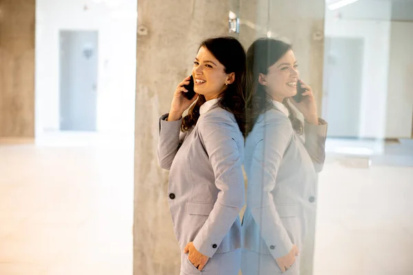 Ładna Młoda Kobieta Biznesu Pomocą Telefonu Komórkowego Korytarzu Biurowym — Zdjęcie stockowe