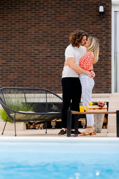 一对年轻貌美的夫妇在自家后院的游泳池边放松一下 — 图库照片