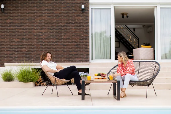 一对年轻貌美的夫妇在自家后院的游泳池边放松一下 — 图库照片