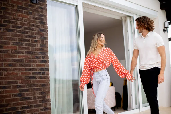 stock image Handsome ymiling young couple in love walking in front of house brick wall