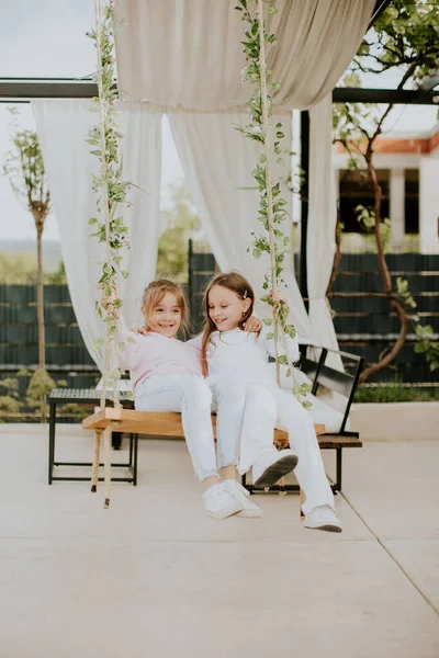 stock image Two cute little girls on the swing in the house backyard