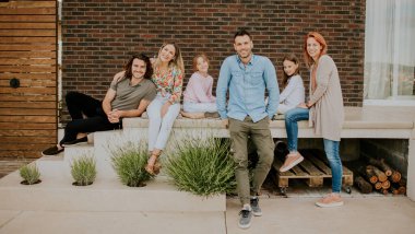 Mutlu bir grup genç ve çocuk evin arka bahçesinde iyi vakit geçiriyorlar.