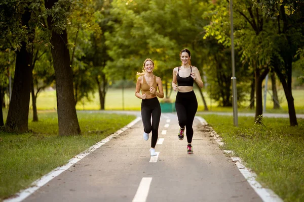 Due Belle Giovani Donne Che Corrono Una Corsia Nel Parco — Foto Stock