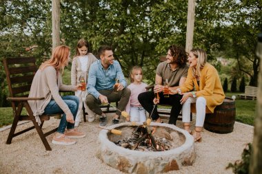 Bir grup arkadaş evin arka bahçesinde mısır pişirip eğleniyorlar.