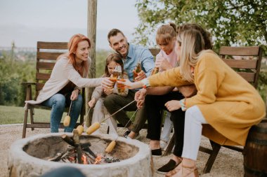 Bir grup arkadaş evin arka bahçesinde mısır pişirip eğleniyorlar.
