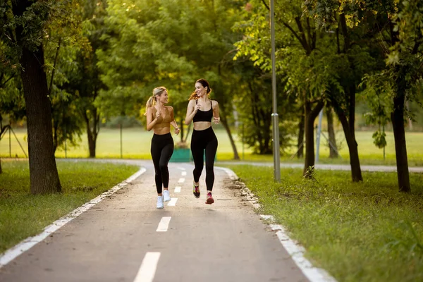 Två Vackra Unga Kvinnor Som Springer Körbana Parken — Stockfoto