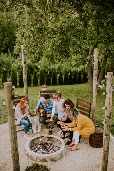 有一群朋友在自家后院玩乐和烘烤玉米 — 图库照片