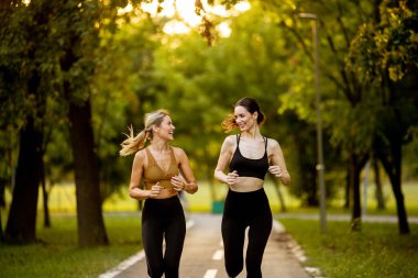 Parkta sokakta koşan iki güzel genç kadın.