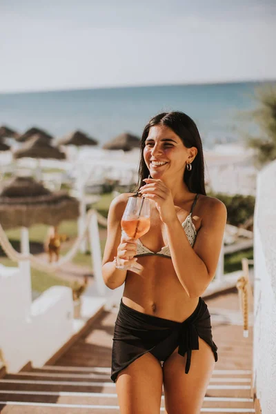 Mujer Joven Sonriente Bikini Disfrutando Vacaciones Playa Mientras Bebe Cóctel —  Fotos de Stock