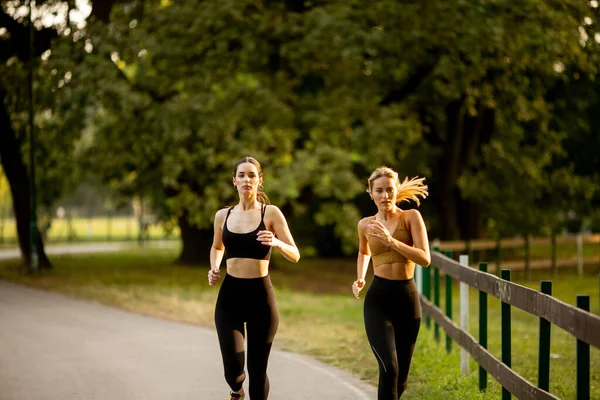 两个漂亮的年轻女子在公园里奔跑 — 图库照片