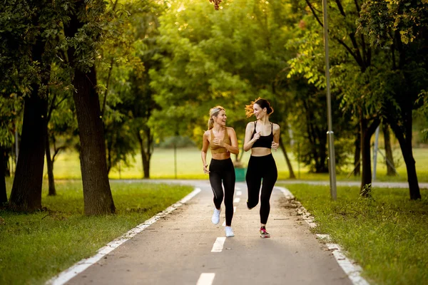 Två Vackra Unga Kvinnor Som Springer Körbana Parken — Stockfoto