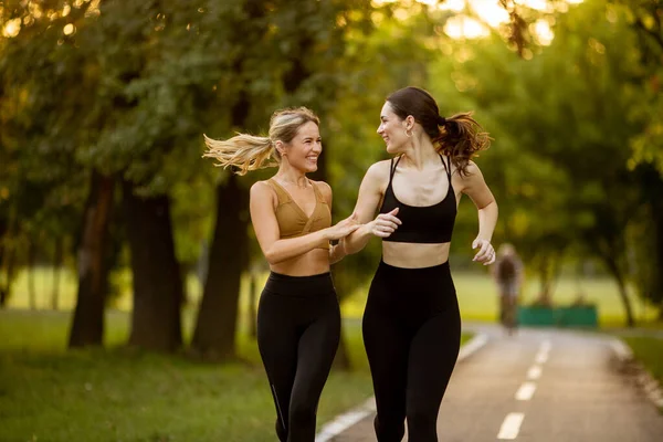 Δύο Όμορφες Νεαρές Γυναίκες Τρέχουν Μια Λωρίδα Στο Πάρκο — Φωτογραφία Αρχείου