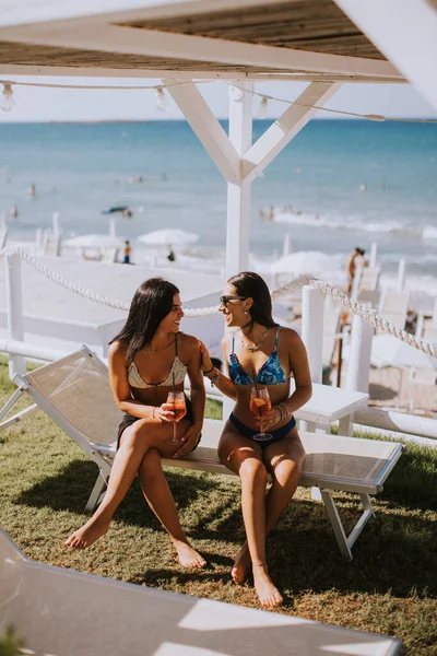 Δύο Χαμογελαστές Νεαρές Γυναίκες Μπικίνι Απολαμβάνοντας Διακοπές Στην Παραλία Πίνοντας — Φωτογραφία Αρχείου