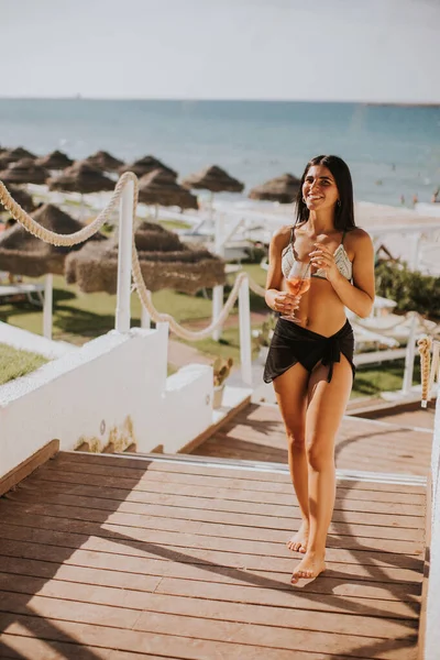 Gülümseyen Genç Kadın Bikini Kokteyl Içerken Tatilin Tadını Çıkarıyor — Stok fotoğraf