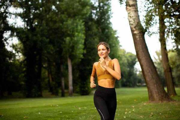 年轻漂亮的女人在公园跑步 — 图库照片