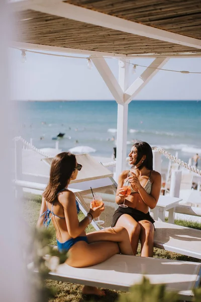 Dvě Usměvavé Mladé Ženy Bikinách Užívají Dovolenou Pláži Popíjejí Koktejl — Stock fotografie