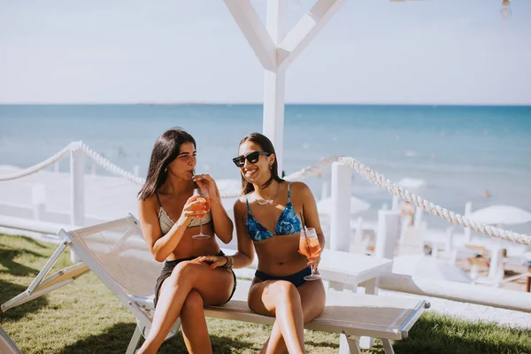 Две Улыбающиеся Девушки Бикини Наслаждаются Отдыхом Пляже Выпивая Коктейль — стоковое фото
