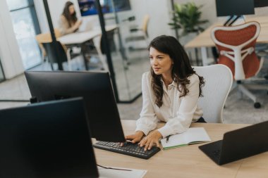 Modern ofiste dizüstü bilgisayarla çalışan güzel bir iş kadını.
