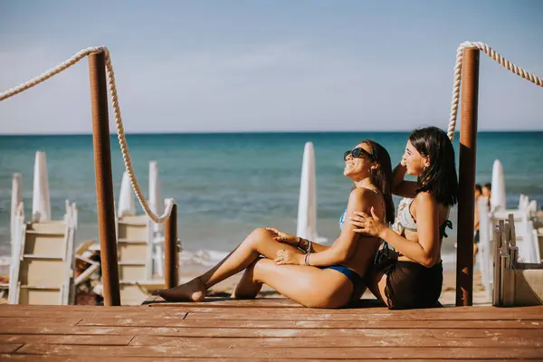 Dwie Uśmiechnięte Młode Kobiety Bikini Siedzą Cieszą Się Wakacjami Plaży — Zdjęcie stockowe
