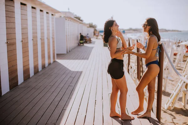 Dos Jóvenes Sonrientes Bikini Pie Junto Las Cabañas Disfrutando Unas — Foto de Stock