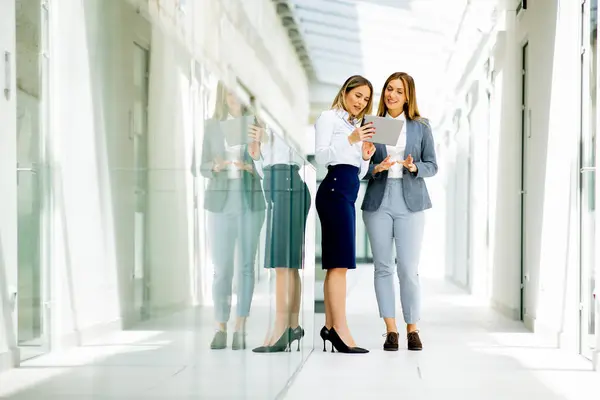 Two Pretty Young Business Women Digital Tablet Office Hallway — Stock Photo, Image
