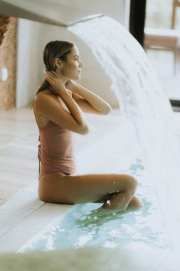 Kapalı havuzda dinlenen genç ve güzel bir kadın.