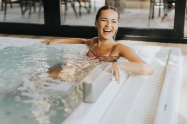 Kapalı havuzda dinlenen güzel genç bir kadın.