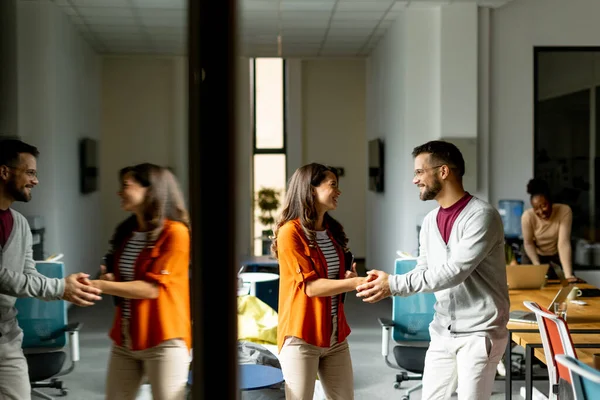 若いビジネスカップルは 現代のオフィスで彼女のチームの前に立って握手 — ストック写真