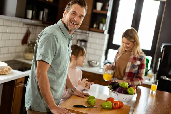 Man Cuts Bell Peppers Child Observes Woman Sipping Orange Juice — Stock Photo, Image